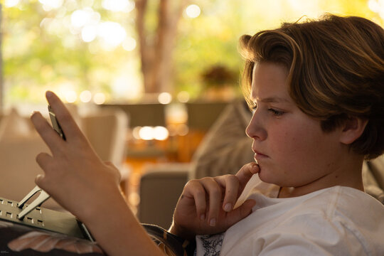 close up profile of pre teen boy looking at tablet computer at home