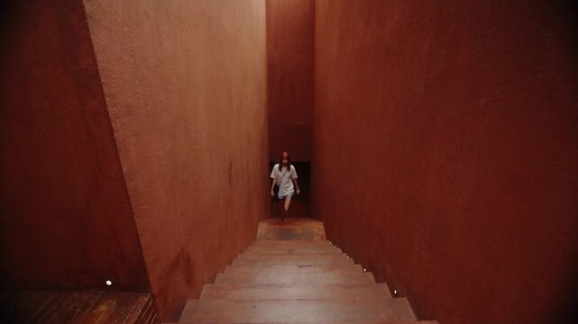 Young woman ascending a terracotta staircase