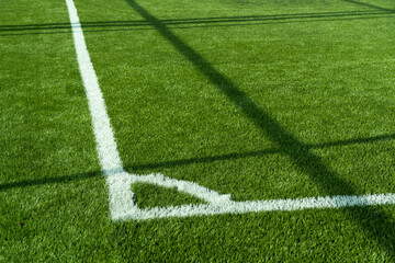 Fototapeta premium green artificial grass football or soccer field with white line corner background. 
