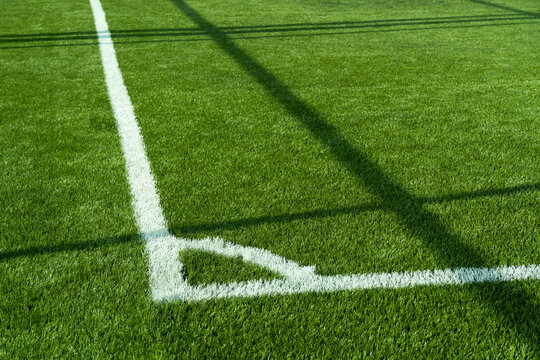 green artificial grass football or soccer field with white line corner background.	