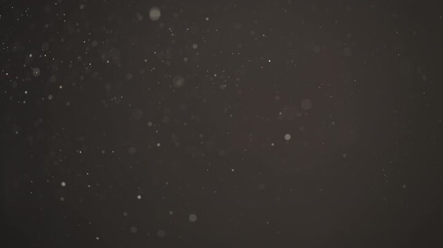 Floating dust particles over dark background with shallow focus