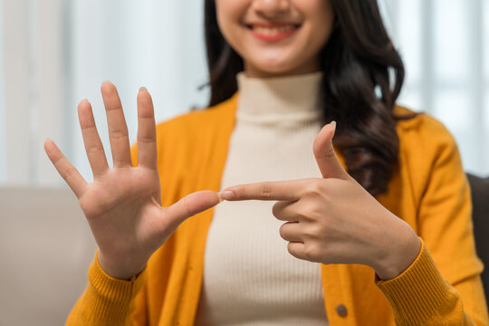 Young deaf asian woman showing sign language. a woman with hearing disability having communication with hands gestures Communicate online using sign language via a laptop.