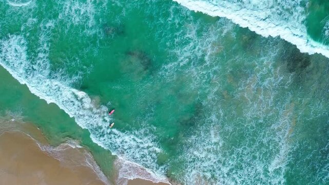 Flowing pool water merging into ocean waves at the coastline, blue sea surf with foam, summer beach shore, tide and natural energy