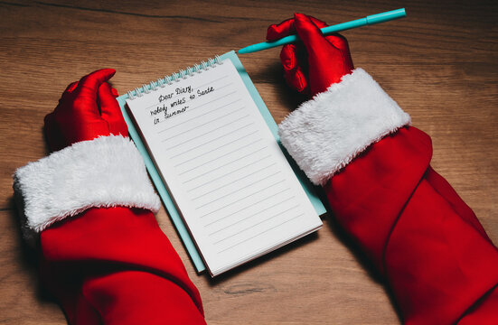 Santa Claus writing a humorous message in a diary during summer
