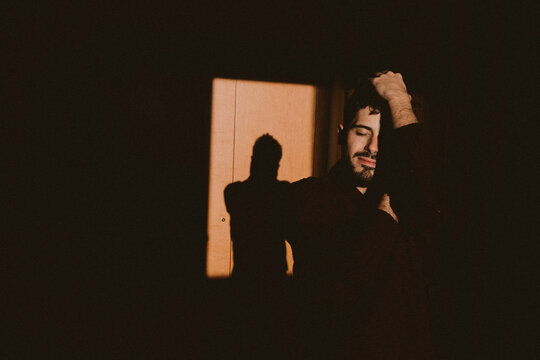 Artistic portrait showing self reflection and shadow play indoors