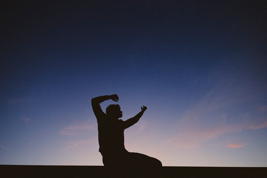 Silhouette of dancer performing contemporary dance at twilight