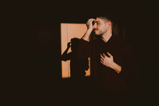 Dancer expressing deep emotion in dramatic indoor window light