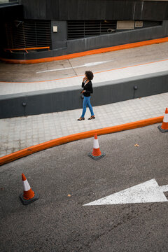 Businesswoman on the phone walking on pavement