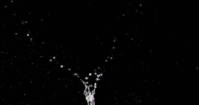 This abstract video features mesmerizing water droplets splashing dramatically after a solid object falls against a dark background, perfect for motion graphics and visual effects in projects