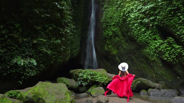 4k Slow motion video.Young female tourist tourist on the background of Leke Leke waterfall in Bali island, Indonesia.