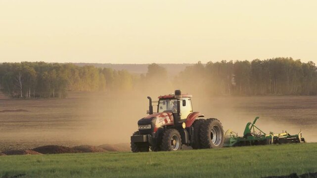 Modern Tractor with Dual Wheels Cultivating Field at Sunset During Agricultural Operations