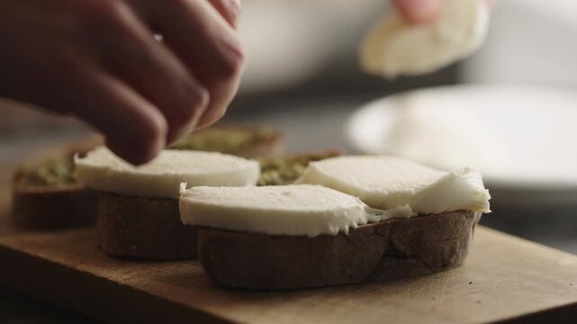 man spread pesto sauce on bread to make sandwich