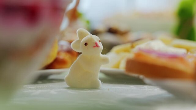 Hand places an Easter bunny decoration onto a festive family holiday table