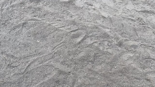 Tire tracks on dusty concrete ground at construction site