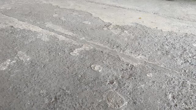 Damaged concrete surface with cracked cement and gravel