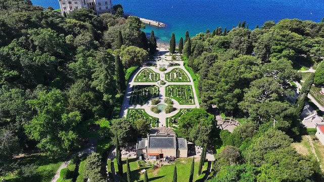 Trieste, Italy - 4K Flying above the beautiful Miramare Castle (Castello di Miramare) by the Gulf of Trieste on a sunny summer day with blue sky and turqoise sea water