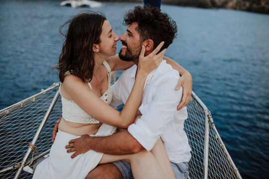 Smiling couple embracing on a sailboat during summer vacation