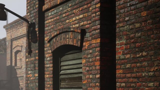A brick wall stands in an old city alley. A lamp is attached to the wall. The sun is rising and casts soft light on the bricks. The scene shows a quiet moment in the city.