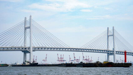波立つ海面とガントリークレーンが織りなす、白い大橋「横浜ベイブリッジ」のある港町風景 © ToYoPHoTo