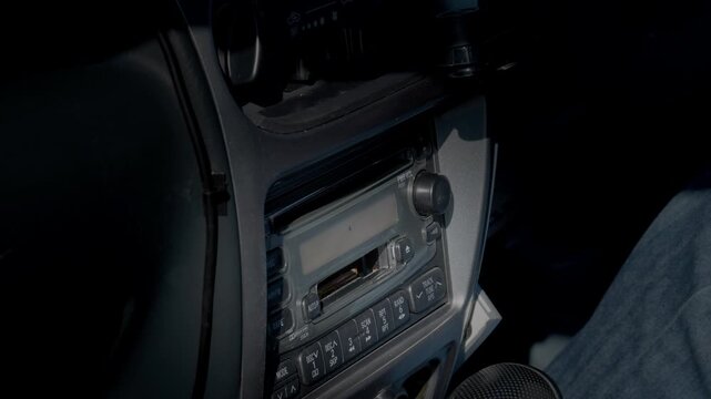 Inserting a Cassette Into a Retro Factory Car Stereo. Operating Controls to Play, Fast-Forward, and Rewind  |  Japan