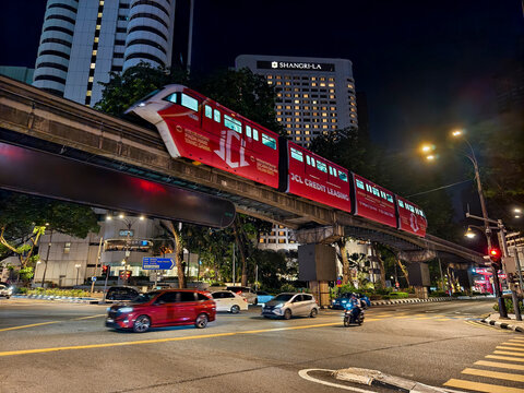Kuala Lumpur, Malaysia - March 8, 2026: Rapid KL monorail passing above busy city streets with traffic and illuminated buildings at night.