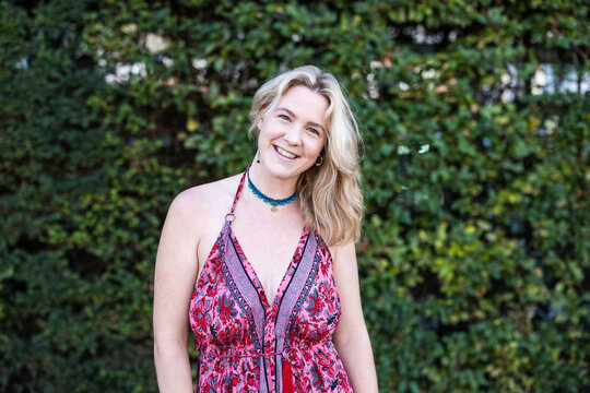 Smiling woman wears a pink dress outdoors in Berlin