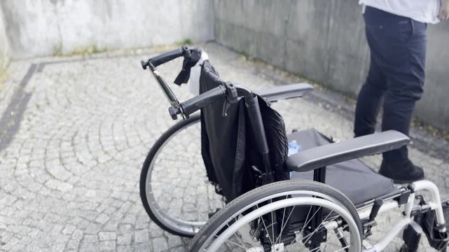 Empty wheelchair on outdoor cobblestone path