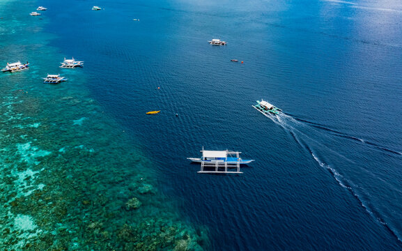 Aerial View of Bangka Boats as sand beach by a crystal clear water. Entalula island, Bacuit Bay, El Nido, Palawan, Philippines.