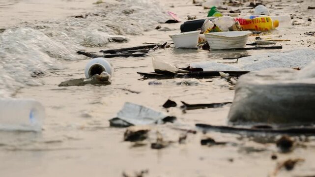 Polluted beach with plastic waste and garbage washed up on the shore, environmental pollution and ocean waste concept, ecological problem on tropical coast	