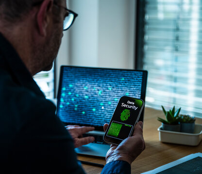 Businessman checks data security on his smartphone at the office