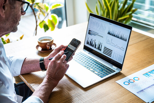 A male broker analyzes financial data on a notebook in the office