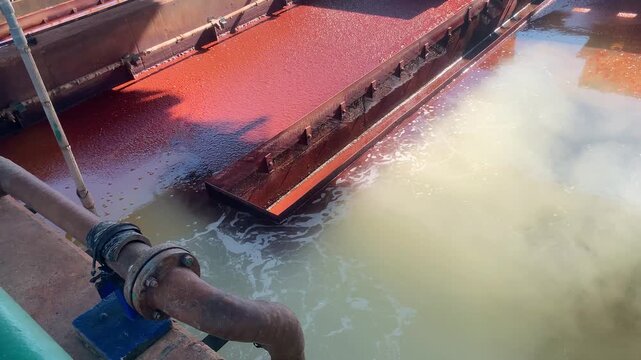 Intriguing Industrial Scene Featuring a Water Surface with Distinctive Coloration and Texture