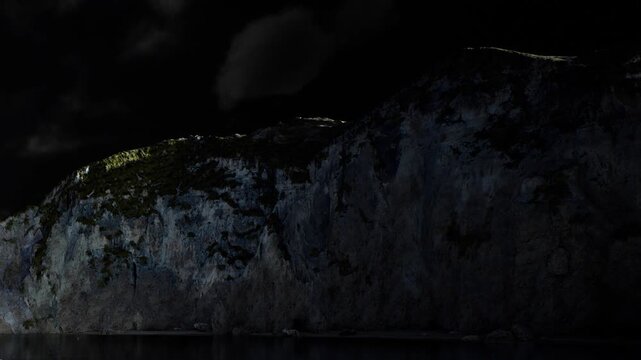 A group of people gathers on a dark shore. They look up at a tall cliff illuminated by a small light. The night sky is clear with a few clouds visible.