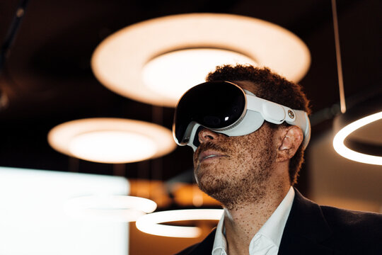 A businessman wears a virtual reality headset in a modern office