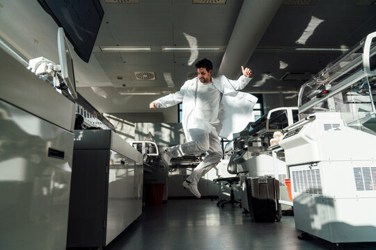 Excited doctor jumping for joy in a modern laboratory