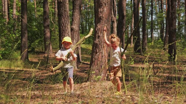 Two children stand among tall trees in a forest, joyfully swinging sticks like swords. Sunlight filters through the leaves, creating a fun atmosphere