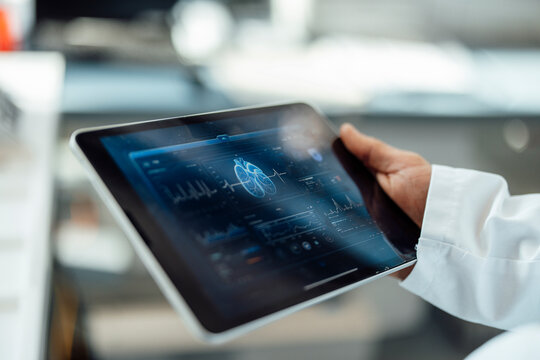 Doctor holding tablet with medical lung analysis in laboratory
