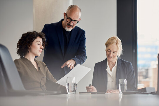 A manager points at a document during a boardroom meeting in London