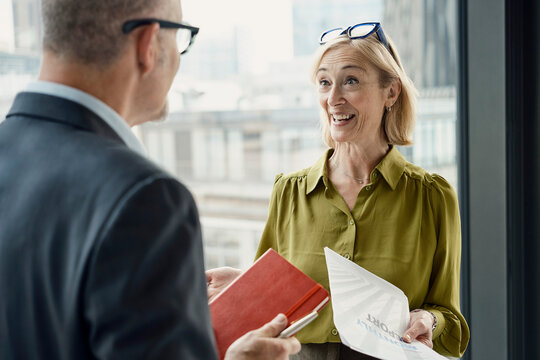 Businessman and businesswoman discuss a report in a London office