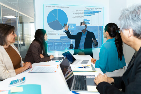 Businessman presents holographic data with virtual reality in office