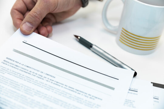 Male hand holds a legal business contract on an office desk