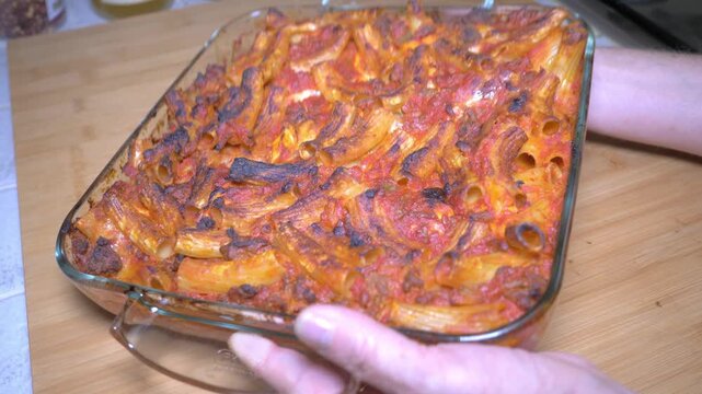 A golden baked rigatoni pasta emerges from the oven, its crispy top and rich filling showcasing the authentic beauty of a classic southern Italian pasta al forno ready to be served.