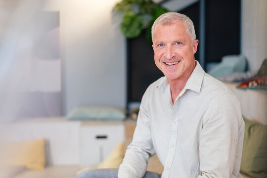 Smiling businessman looking at camera in modern office