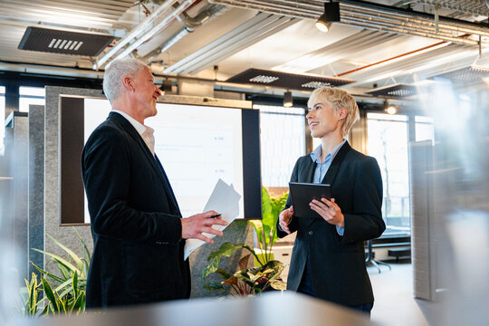 Smiling businessman and businesswoman plan strategy in the office