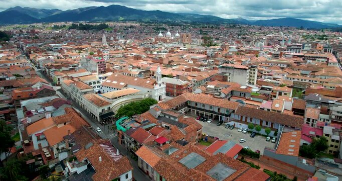 cinematic drone flying forward approaching the beautiful la merced church in cuenca ecuador revealing the gorgeous historic city skyline in the background on a stunning clear sunny day with blue skies