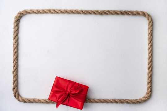 Red gift box with rope on cozy Christmas background, copy space