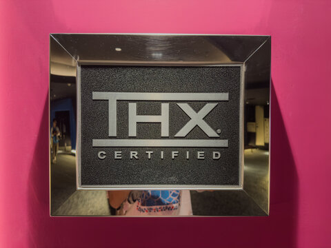 THX Certified audio quality sign on a bright pink wall in a cinema.