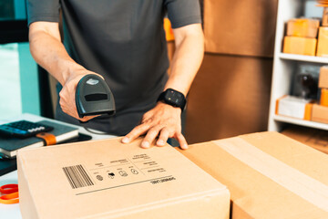 Handheld Barcode Scanner Scanning Shipping Parcel at Packaging Workspace © thanmano