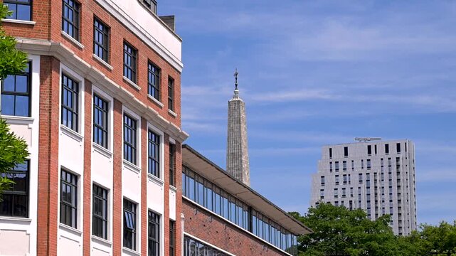 St Luke's Church spire rises behind Old Street brick offices and a modern tower on a clear summer day.
