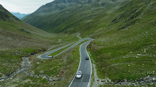 Aerial landscape of a vehicle driving through the Timmelsjoch High Alpine Road in Tyrol with rugged mountain peaks scenic valleys and alpine nature